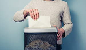 man shredding financial documents